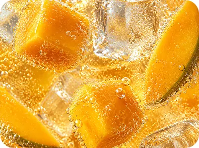 Mango pieces and ice in a sparkling drink